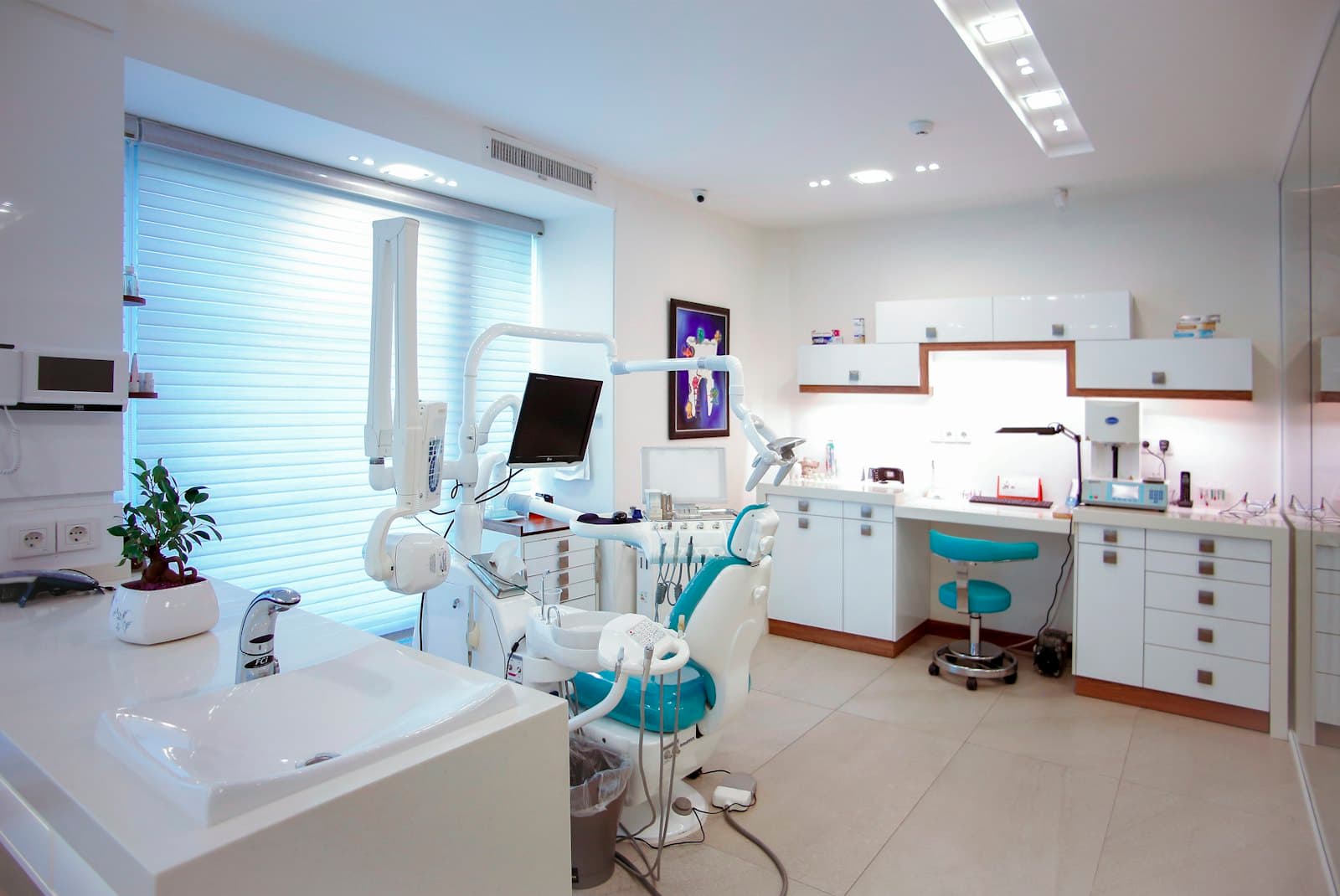 A bright treatment room with a dental chair by the window