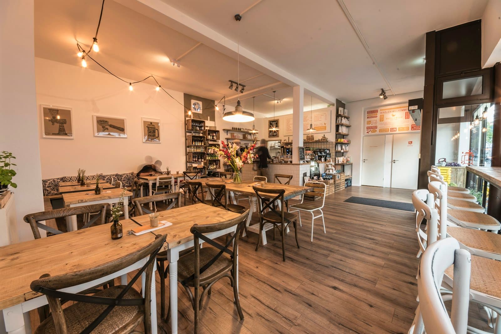 The café: wooden tables, string lights and the counter at the back