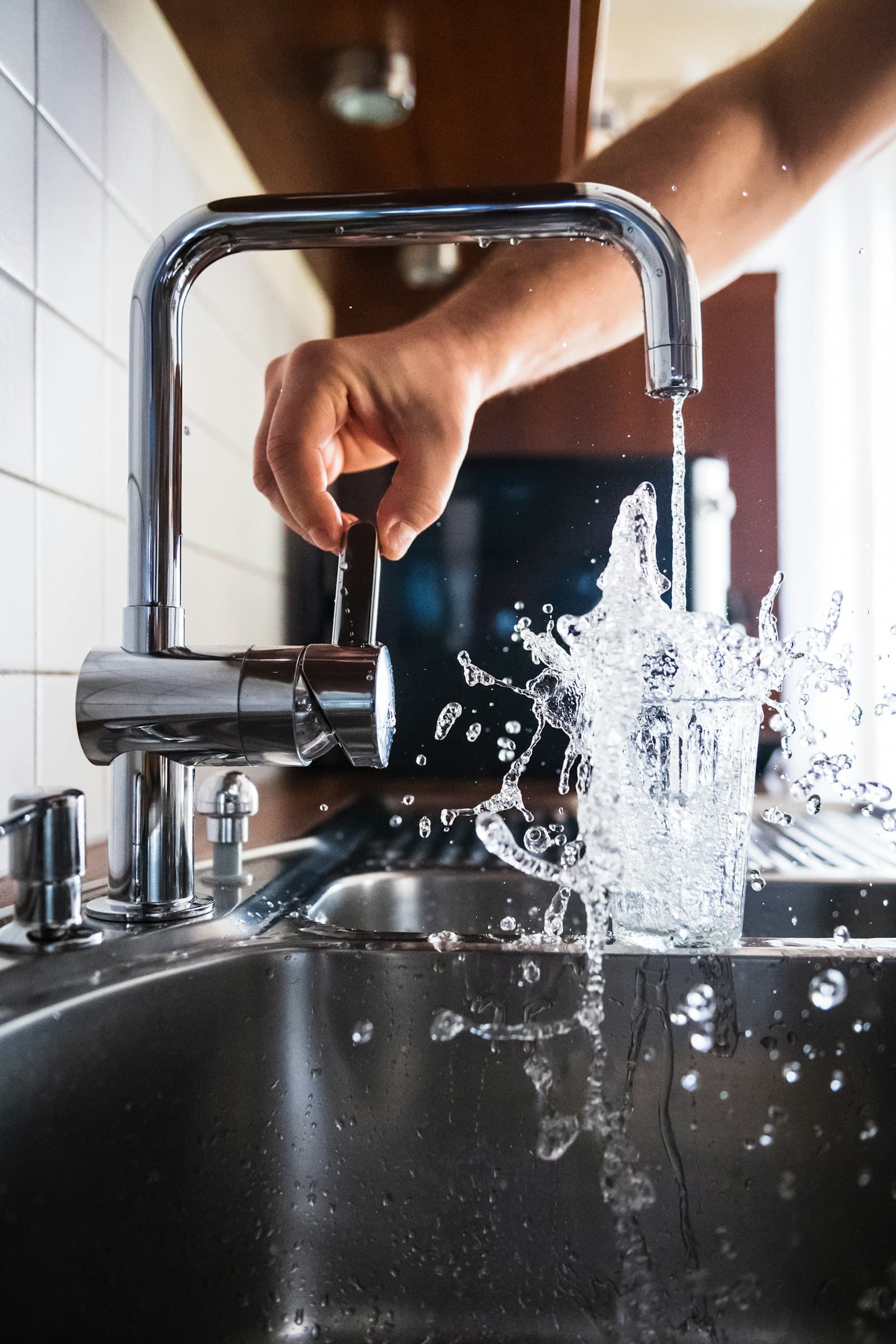 A kitchen tap running into a glass